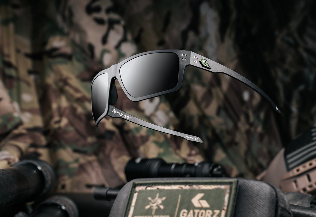Green Beret Foundation x GATORZ Sentix sunglasses displayed above camouflage tactical gear with a GBF and GATORZ patch