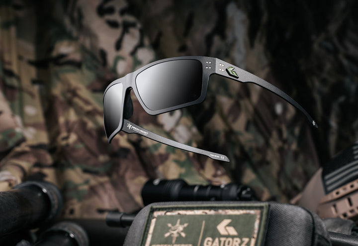 Green Beret Foundation x GATORZ Sentix sunglasses displayed above camouflage tactical gear with a GBF and GATORZ patch