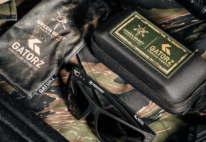 Green Beret Foundation x GATORZ Sentix sunglasses with co-branded pouch and patched hard case on tiger stripe camouflage