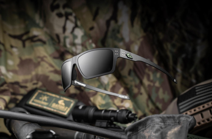 Green Beret Foundation x GATORZ Sentix black sunglasses resting on camouflage gear